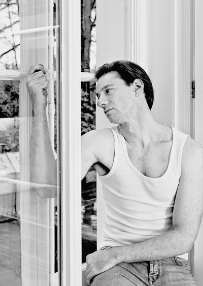 Christopher Fliether Schauspieler - sitzt im Unterhemd am Fenster männlich Portätfotografie ist angestellt im Hamburg Dungeon - 2010 Foto Peter Koehn