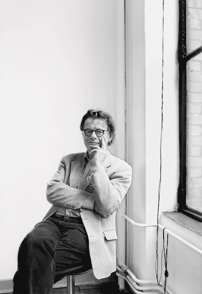 Jan Störmer Architekt - sitzt in seinem Atelier vor einem Fenster - 2015 Foto Peter Koehn