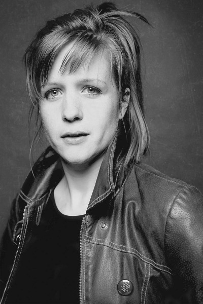 Julia Nachtmann Schauspielerin - steht in Lederjacke und sieht in die Kamera blonde Haare schwarz weiß Foto - 2012 Foto Peter Koehn