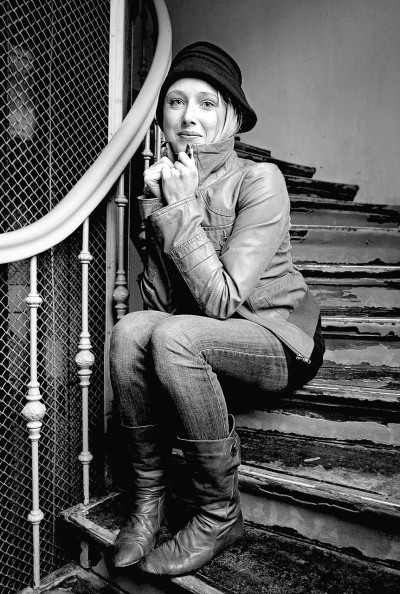 Kristina Weber Schauspielerin - sitzt im alten Treppenhaus auf den Stufen lehnt am Geländer lacht hübsch schwarz weiß Foto - 2010 Foto Peter Koehn