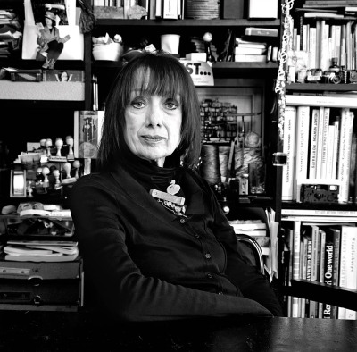 Margit Tabel-Gerster Fotografin - sitzt an ihrem Schreibtisch im Hintergrund ein Regal mit Büchern schwarweiß Porträt - 2010 Foto Peter Koehn