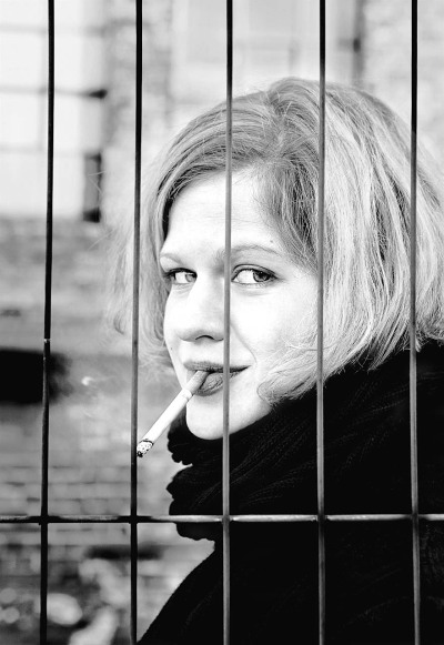 Marie Grust Schauspielerin - steht vor Gitter auf Baustelle und raucht blonde Haare schwarzer Schal sexy - 2015 Foto Peter Koehn