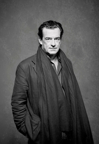 Thomas Sarbacher Schauspieler - steht in schwarzer Jacke mit langem Schasl im Fotostudio Hände in den Taschen - 2012 Foto Peter Koehn