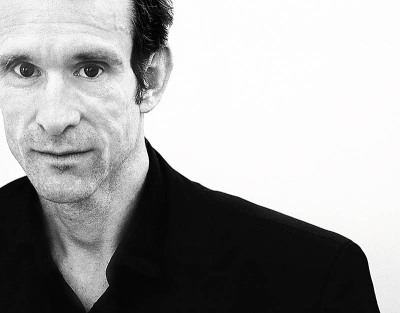 Ulrich Matthes Schauspieler - steht vor weißer Wand mit schwarzem Sakko und schwarzem Hemd bekam die Goldene Kamera 2015 als Schauspieler des Jahres - 2015 Foto Peter Koehn