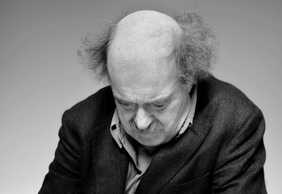 Urs Widmer Schriftsteller - hockt auf Fußboden guckt traurig nach unten schwarz weiß Foto Porträt - 2012 Foto Peter Koehn